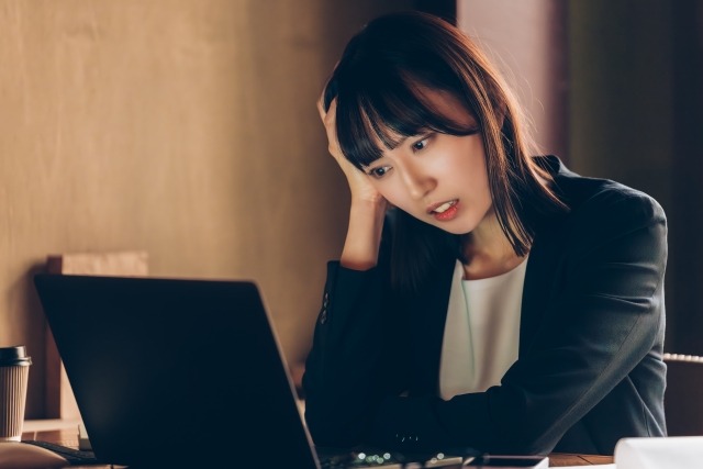 忙しく働く成人女性のイメージ写真