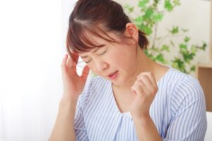 こめかみを抑える人物のイメージ写真