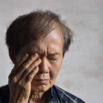 目を抑える男性のイメージ写真