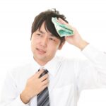 汗を拭く人物のイメージ写真
